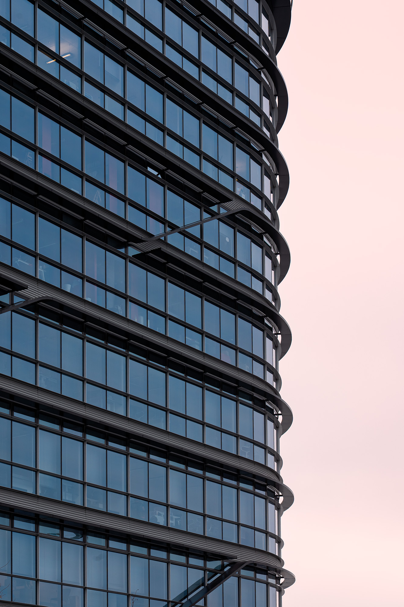 Architektonische Fassade in Prag bei warmem Licht, moderne Linien und reflektierende Glasstruktur.